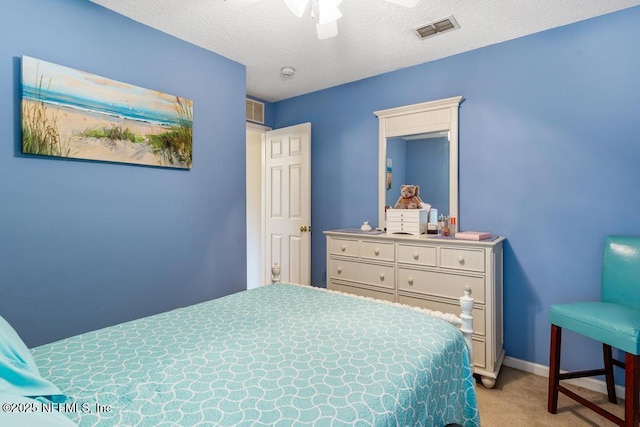 bedroom with a textured ceiling, baseboards, visible vents, and carpet floors