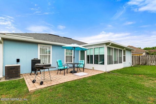 back of property with a shingled roof, a patio area, a lawn, fence, and central air condition unit