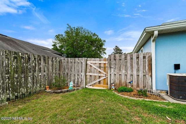 view of yard featuring central air condition unit, fence, and a gate