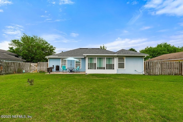 back of property with a patio area, roof with shingles, a fenced backyard, and a yard