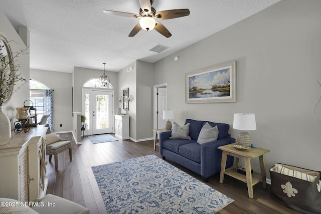 living area featuring ceiling fan, dark wood-style floors, a textured ceiling, and visible vents