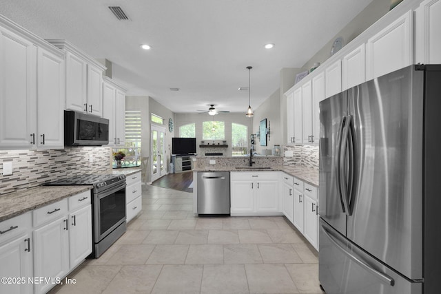 kitchen featuring open floor plan, white cabinets, visible vents, and appliances with stainless steel finishes