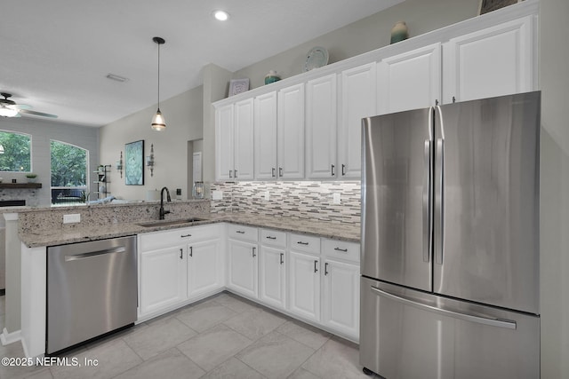 kitchen with white cabinets, a sink, stainless steel appliances, and decorative backsplash