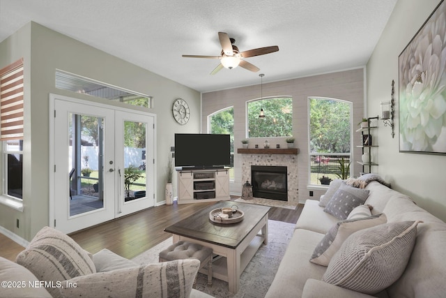living area with plenty of natural light, wood finished floors, and french doors