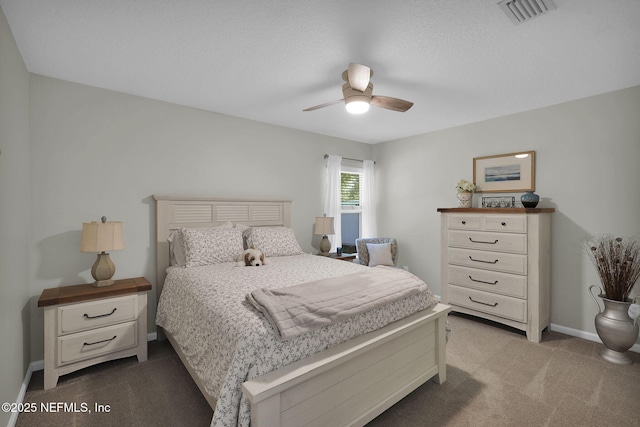 bedroom with baseboards, a ceiling fan, visible vents, and carpet
