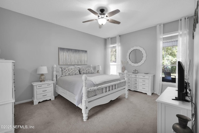bedroom with light carpet, multiple windows, and ceiling fan