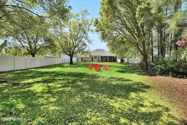 view of yard with a sunroom and a fenced backyard