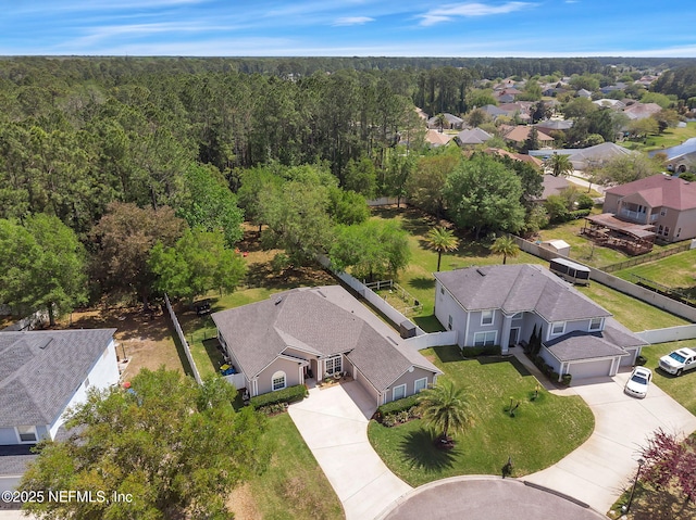 birds eye view of property featuring a wooded view and a residential view