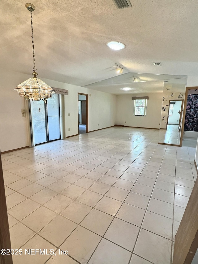 38 Rymer Ln, Palm Coast, FL 32164 - unfurnished room with a textured ceiling, light tile patterned floors, baseboards, a notable chandelier, and lofted ceiling