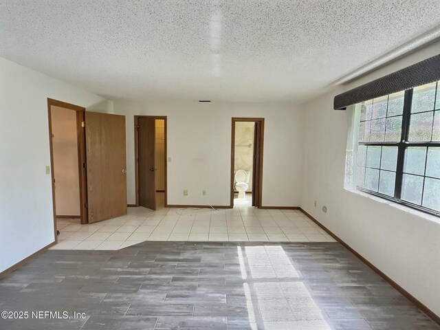 38 Rymer Ln, Palm Coast, FL 32164 - unfurnished room with baseboards, a textured ceiling, and tile patterned flooring