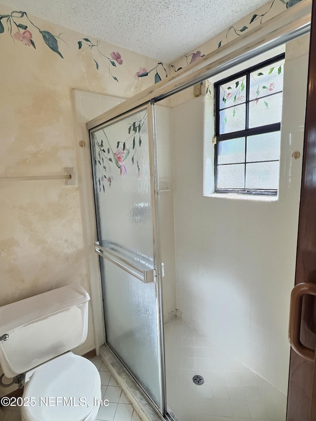 38 Rymer Ln, Palm Coast, FL 32164 - bathroom with toilet, a textured ceiling, tile patterned floors, and a stall shower