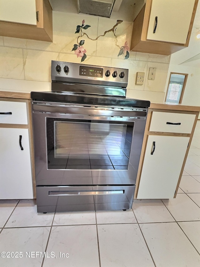 38 Rymer Ln, Palm Coast, FL 32164 - kitchen featuring light countertops, light tile patterned floors, white cabinets, and stainless steel range with electric cooktop