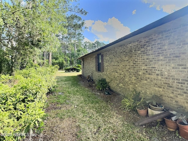 38 Rymer Ln, Palm Coast, FL 32164 - view of side of home featuring a lawn and brick siding