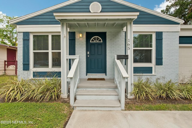 view of exterior entry with brick siding