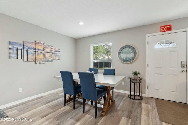 dining room with baseboards, light wood-type flooring, and recessed lighting