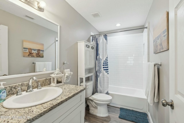 bathroom with visible vents, toilet, vanity, and shower / bath combo
