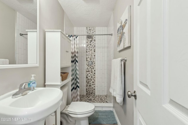 bathroom with a sink, a textured ceiling, toilet, and a shower stall