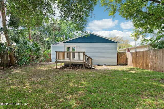 rear view of house featuring a fenced backyard, a yard, crawl space, and a deck