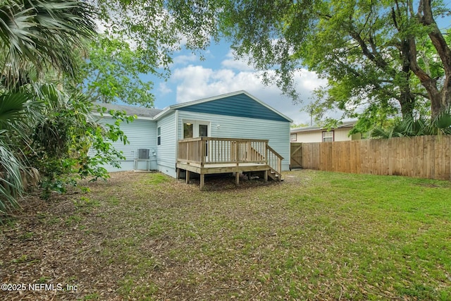rear view of house with a fenced backyard, crawl space, a deck, a lawn, and cooling unit
