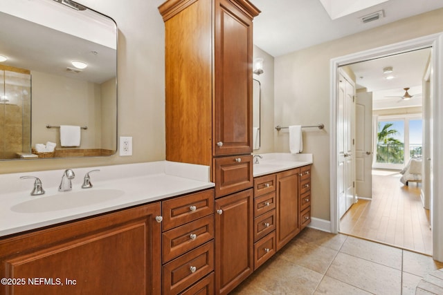 bathroom featuring tile patterned floors, visible vents, a ceiling fan, vanity, and baseboards