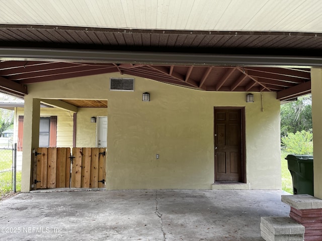property entrance featuring stucco siding and fence