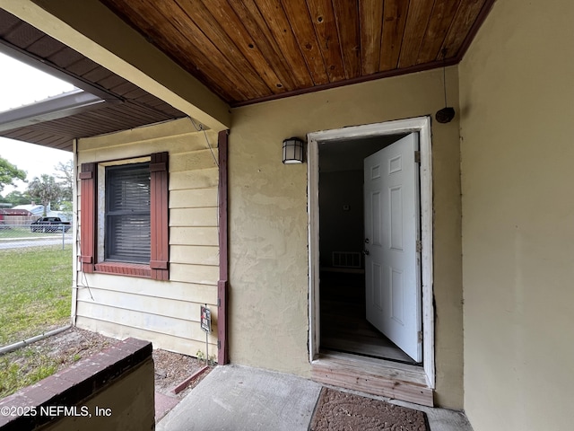 doorway to property with stucco siding and visible vents