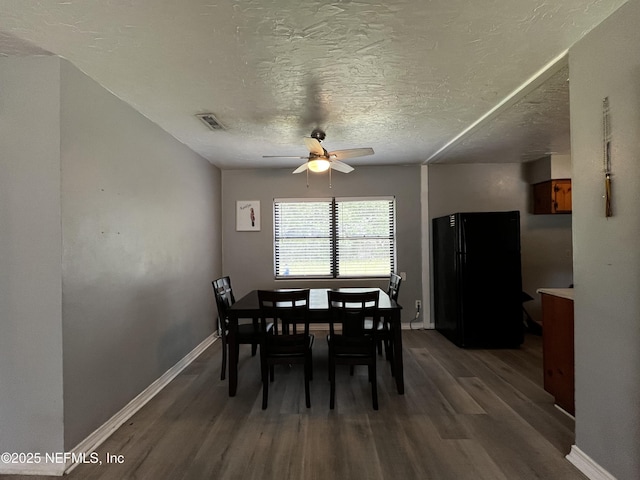 dining room with visible vents, baseboards, wood finished floors, and ceiling fan