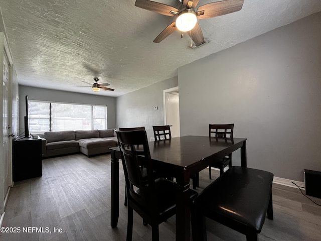 dining area featuring ceiling fan, wood finished floors, and a textured ceiling