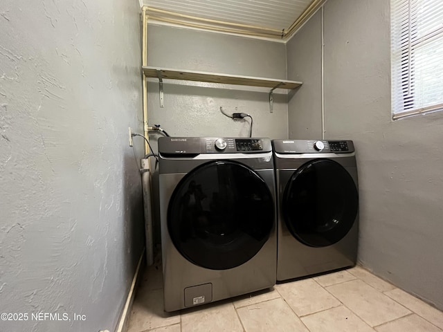 clothes washing area featuring separate washer and dryer, laundry area, and light tile patterned flooring
