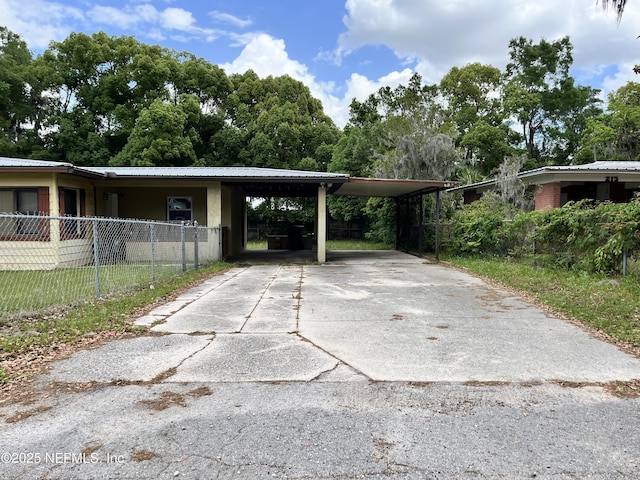 view of car parking with driveway and fence