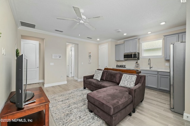 living area featuring ceiling fan, visible vents, wood finish floors, and ornamental molding