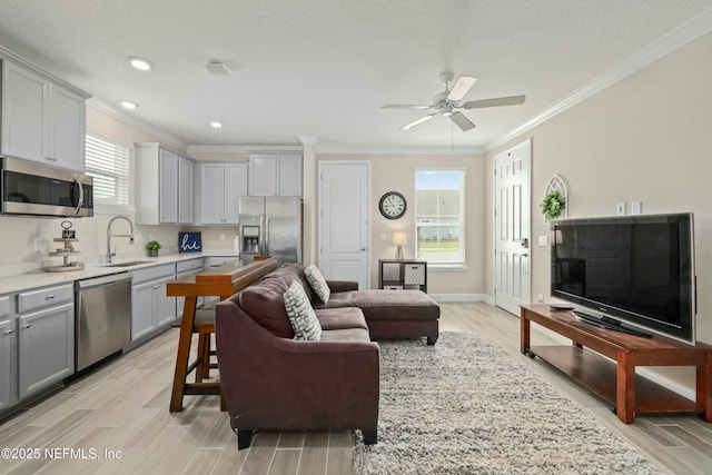 living room featuring crown molding, a textured ceiling, baseboards, wood tiled floor, and ceiling fan