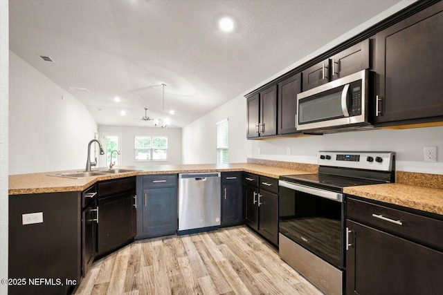 7271 Gateway Ct, Jacksonville, FL 32219 - kitchen featuring stainless steel appliances, a sink, light wood-style floors, a peninsula, and light countertops