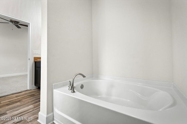 7271 Gateway Ct, Jacksonville, FL 32219 - full bathroom featuring a bath, wood finished floors, a ceiling fan, and baseboards