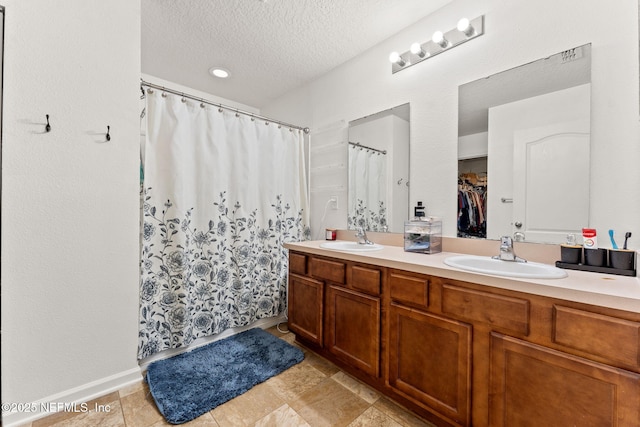 9087 Leicestershire Ct, Jacksonville, FL 32219 - bathroom with a shower with curtain, double vanity, a sink, and a textured ceiling