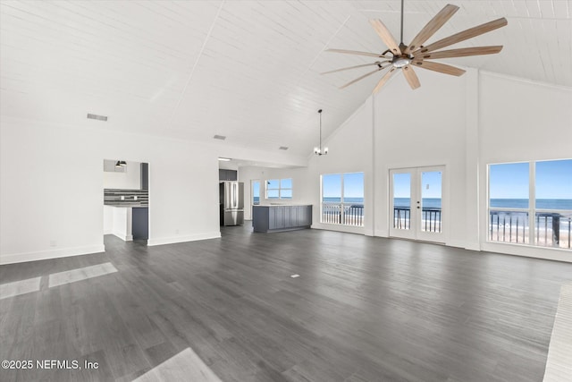 unfurnished living room with visible vents, dark wood-style flooring, a water view, ceiling fan, and a wealth of natural light