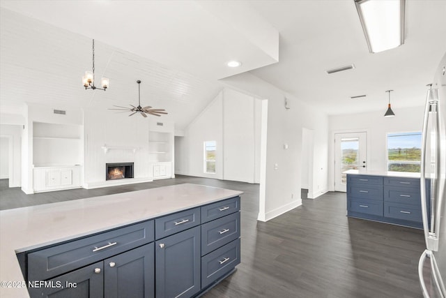 kitchen with dark wood-style flooring, stainless steel fridge, light countertops, lofted ceiling, and ceiling fan with notable chandelier