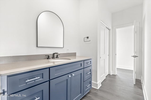 bathroom featuring vanity, baseboards, and wood finished floors