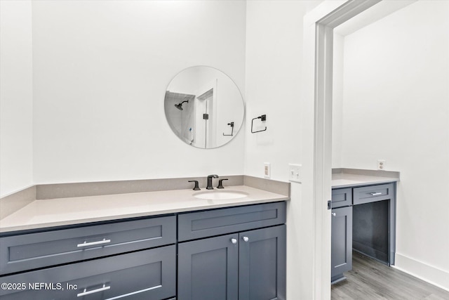 bathroom with baseboards, vanity, and wood finished floors