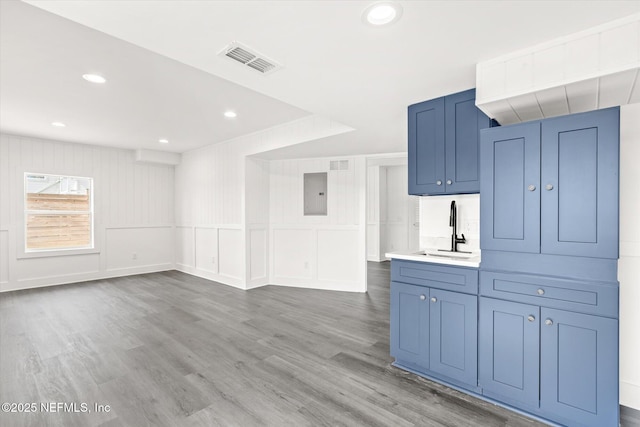 unfurnished living room featuring electric panel, visible vents, recessed lighting, wood finished floors, and a sink