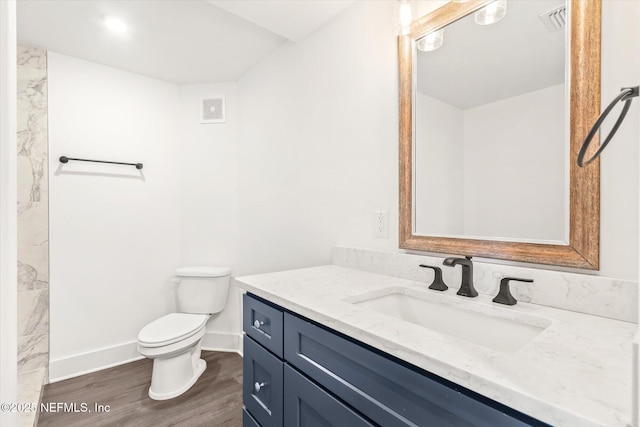 bathroom with visible vents, baseboards, toilet, vanity, and wood finished floors