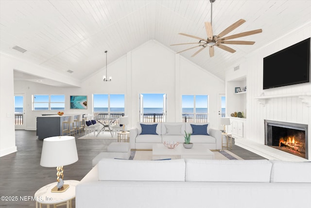 living room featuring ceiling fan, high vaulted ceiling, a lit fireplace, visible vents, and wood finished floors