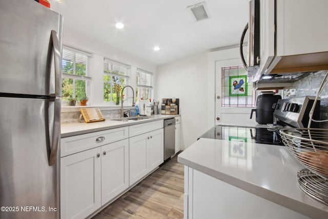 1516 Aberdeen St, Jacksonville, FL 32205 - kitchen with light countertops, stainless steel appliances, a sink, visible vents, and light wood-style flooring