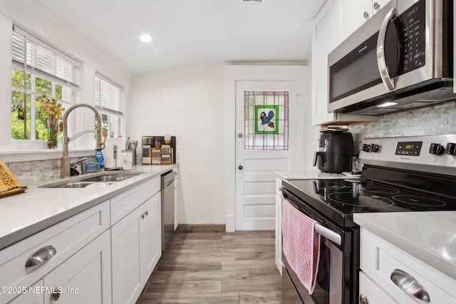 1516 Aberdeen St, Jacksonville, FL 32205 - kitchen featuring light countertops, a sink, stainless steel appliances, white cabinets, and decorative backsplash