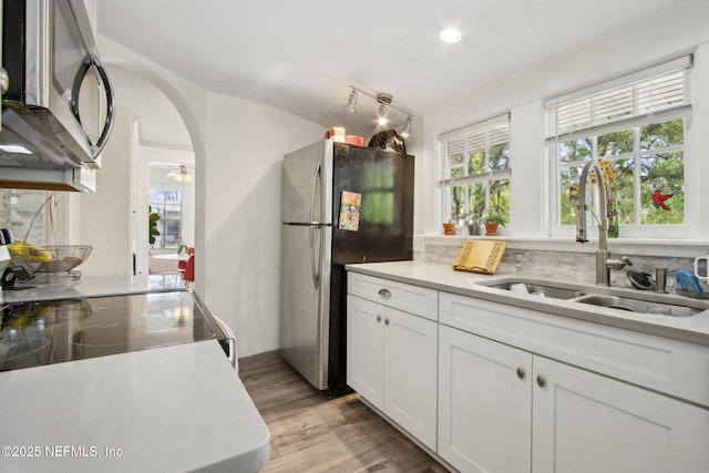 1516 Aberdeen St, Jacksonville, FL 32205 - kitchen with light countertops, light wood-style flooring, white cabinets, appliances with stainless steel finishes, and a sink