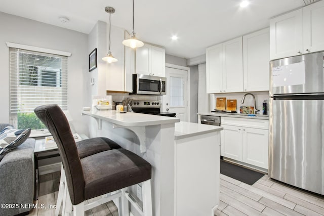 1516 Aberdeen St, Jacksonville, FL 32205 - kitchen featuring light countertops, a sink, backsplash, white cabinetry, and appliances with stainless steel finishes