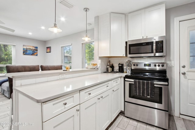 1516 Aberdeen St, Jacksonville, FL 32205 - kitchen featuring light countertops, tasteful backsplash, appliances with stainless steel finishes, a peninsula, and open floor plan