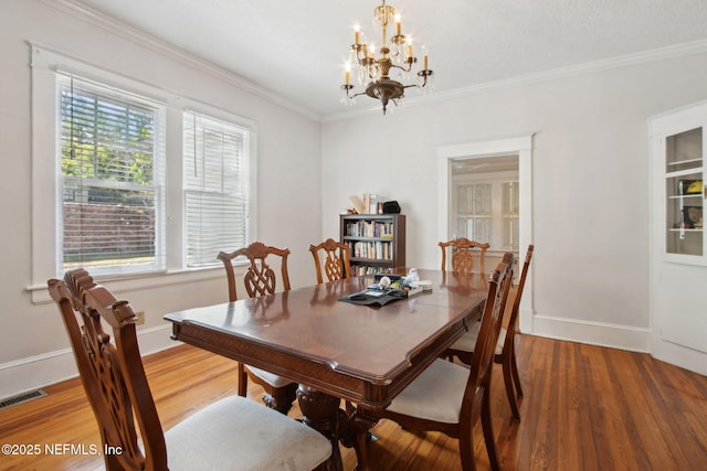 1516 Aberdeen St, Jacksonville, FL 32205 - dining space featuring visible vents, a chandelier, crown molding, baseboards, and wood finished floors