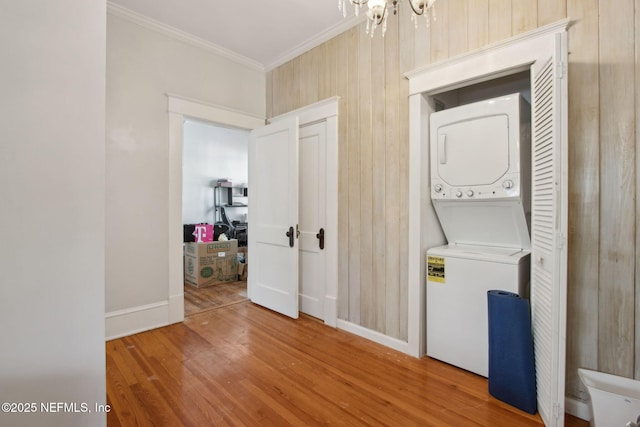 1516 Aberdeen St, Jacksonville, FL 32205 - washroom with wood finished floors, stacked washer and clothes dryer, baseboards, ornamental molding, and an inviting chandelier