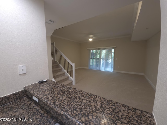 stairway featuring crown molding, a ceiling fan, visible vents, carpet flooring, and baseboards